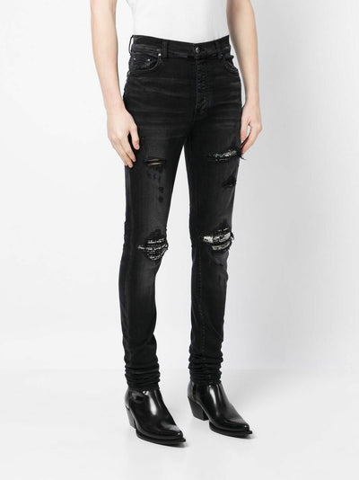 Amiri – Bouclé-MX1-Jeans mit Rissen in Schwarz